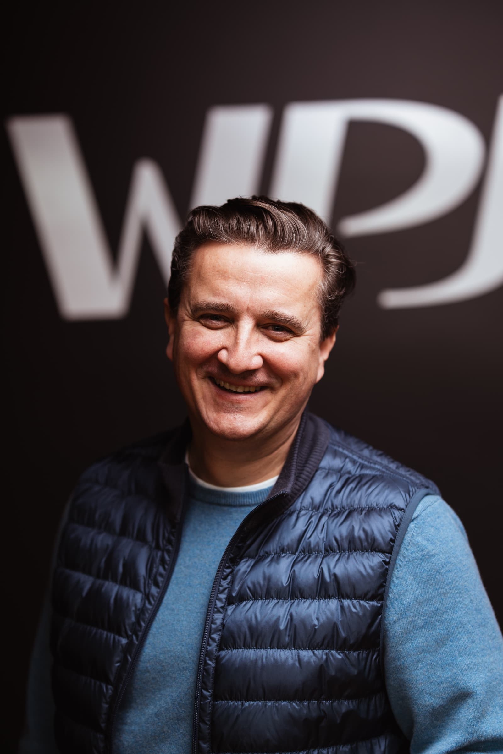Portret zespołu WPJ International na tle logo
